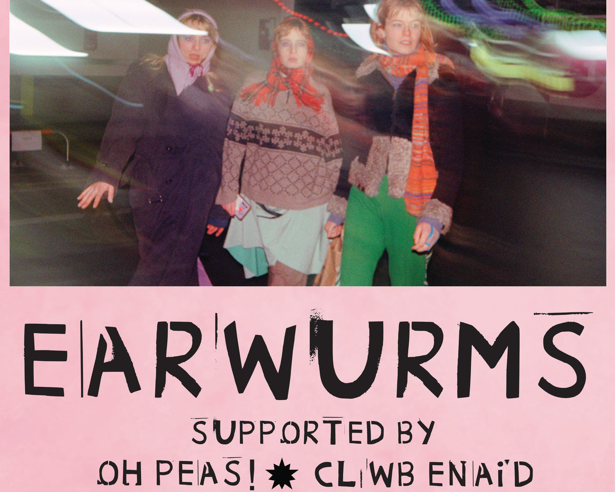 A pink concert poster for the band Earworms, featuring a central photograph of three people walking through a tunnel with motion blur. 